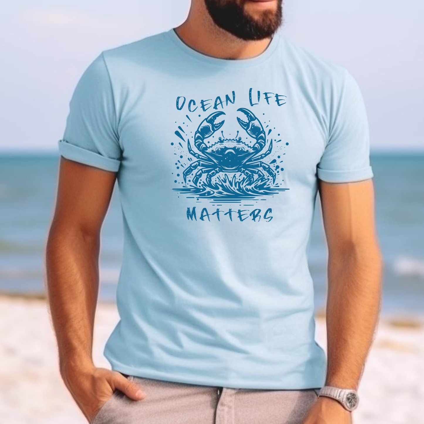 Comfort Colors 1717 "Ocean Life Matters" t shirt with a crab splashing in water in a one color graphic. Picture of a man standing on the beach wearing a t shirt.