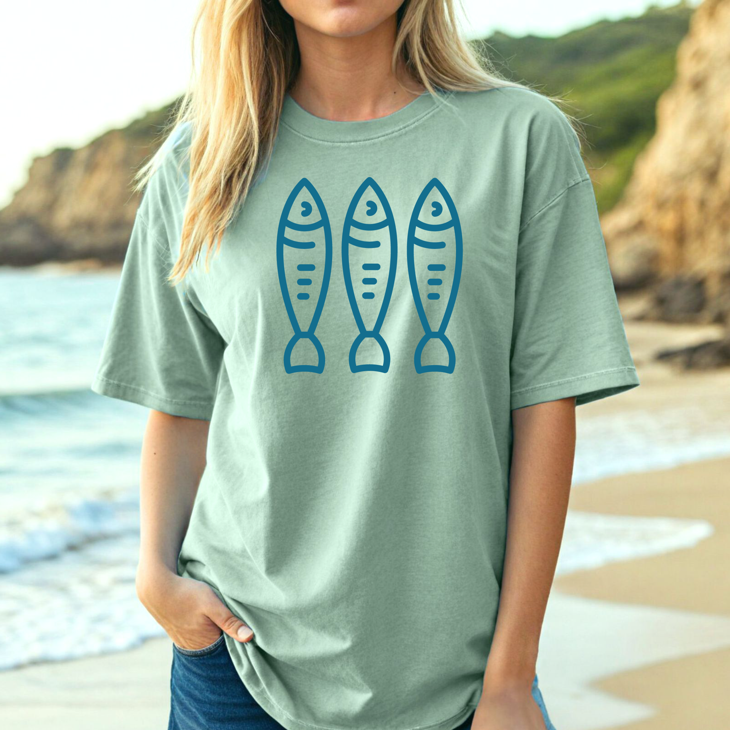 Comfort Colors 1717 Fisherman's Aesthetic t shirt with three sardines in a one color graphic. Picture of a girl on the beach in an oversized t shirt.