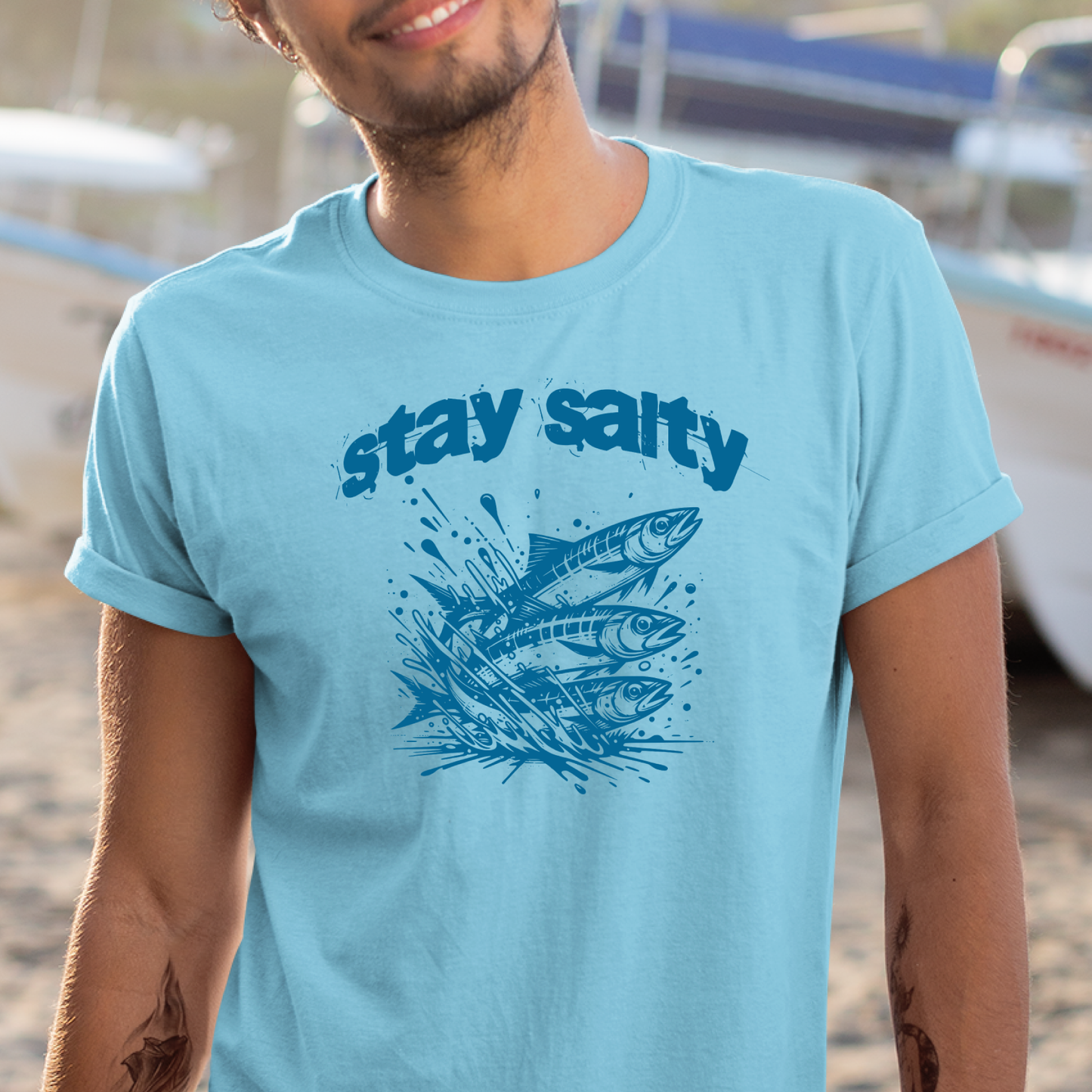 Gildan 5000 "Stay Salty" t shirt with Three Sardines jumping out of water in one color graphics. Picture of a man standing in a ship yard wearing a t shirt.