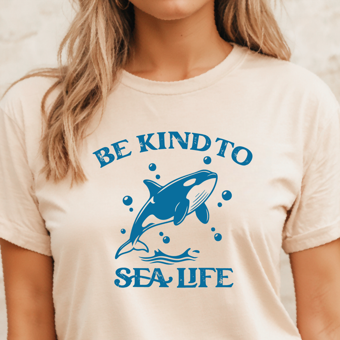 Person wearing a t-shirt with a blue whale graphic and 'Be Kind to Sea Life' text.