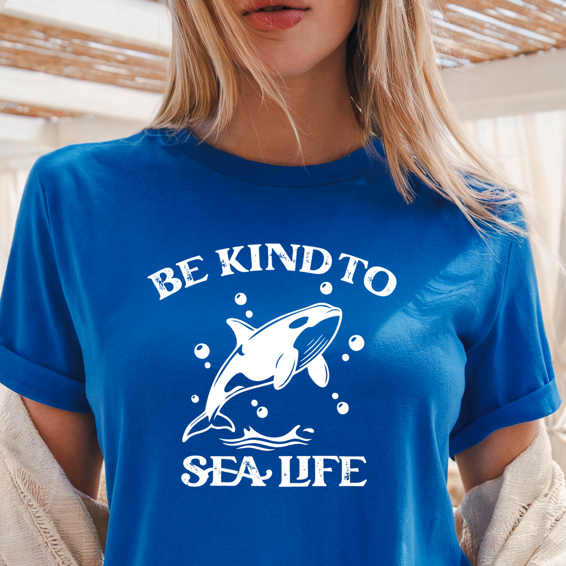 Person wearing a blue t-shirt with a whale graphic and text 'Be Kind to Sea Life'.