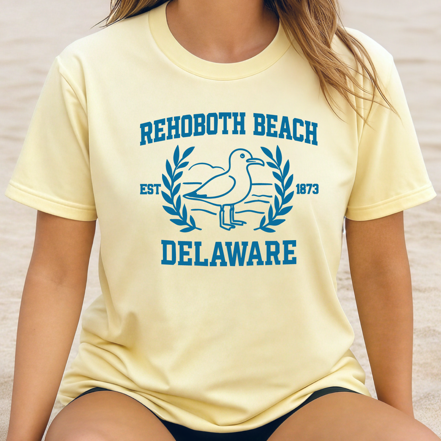 Person wearing a yellow t-shirt with Rehoboth Beach, Delaware text and logo.