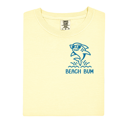 Yellow t-shirt with a blue shark graphic and 'Beach Bum' text on a white background
