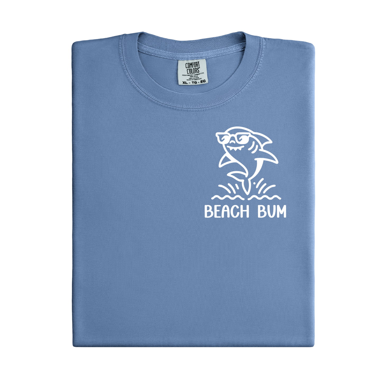 Folded blue t-shirt with a shark graphic and 'Beach Bum' text on a white background