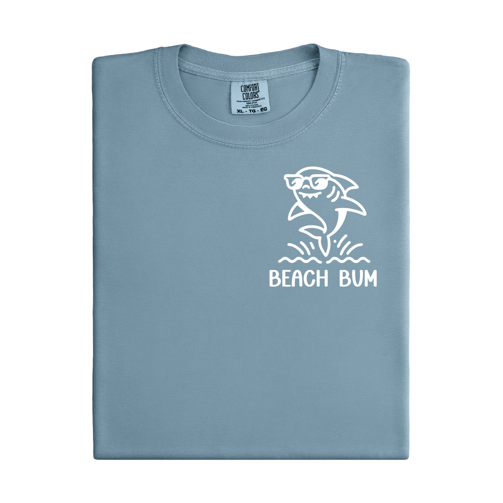 Folded light blue t-shirt with a shark graphic and 'Beach Bum' text on a white background