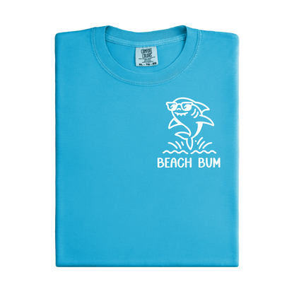 Folded blue t-shirt with a shark graphic and 'Beach Bum' text on a white background