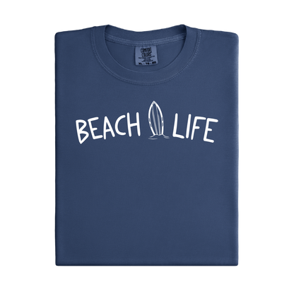 Folded Denim blue t-shirt with 'Beach Life' text and surfboard graphic on a white background