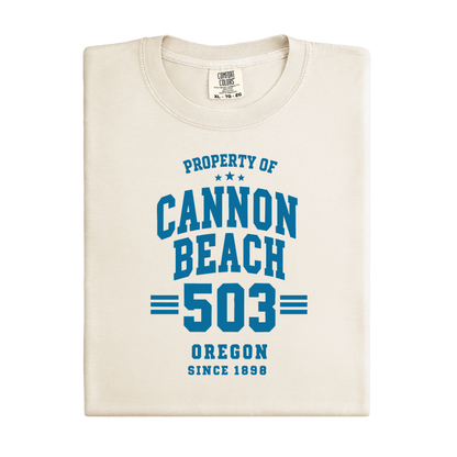Folded t-shirt with 'Property of Cannon Beach 503 Oregon Since 1898' text on a white background