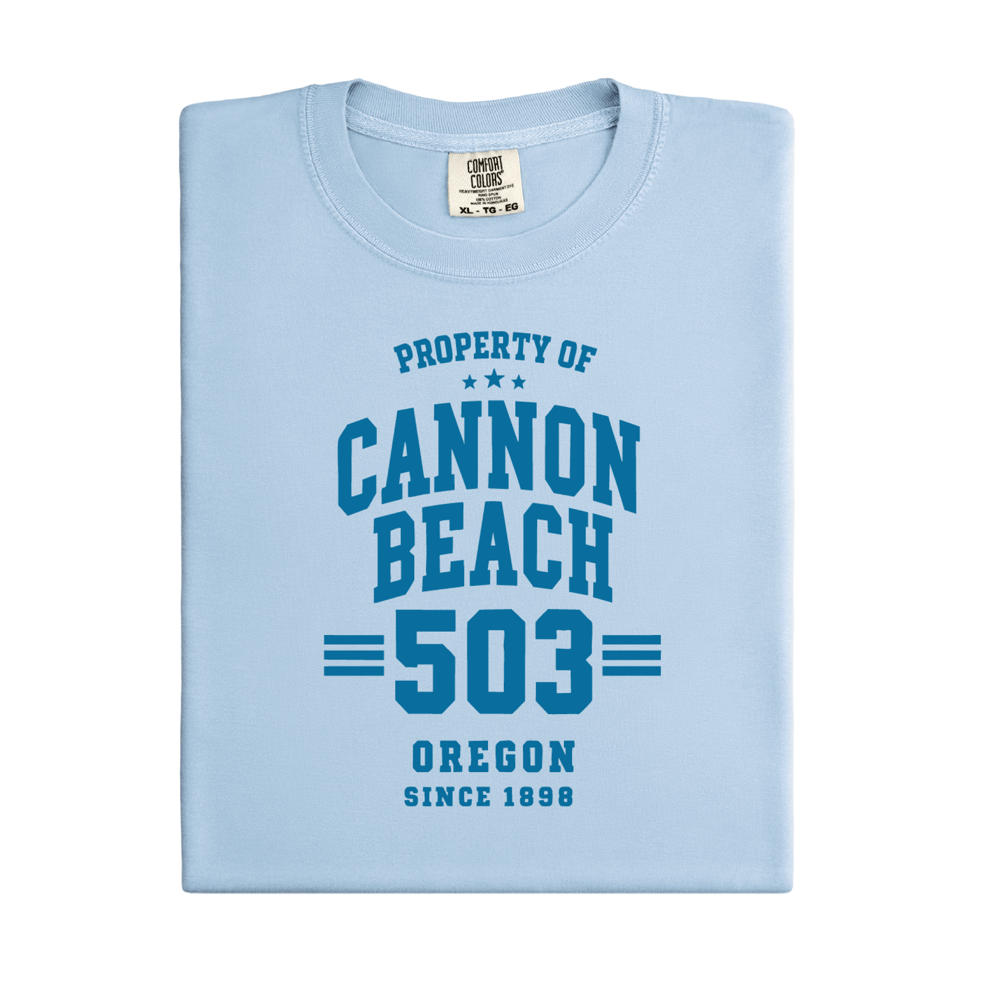 a t-shirt with 'Property of Cannon Beach 503 Oregon Since 1899' text at the beach.