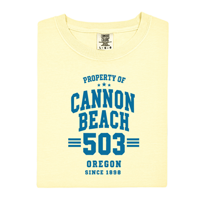 Yellow t-shirt with blue text 'Property of Cannon Beach 503 Oregon Since 1896' on a white background