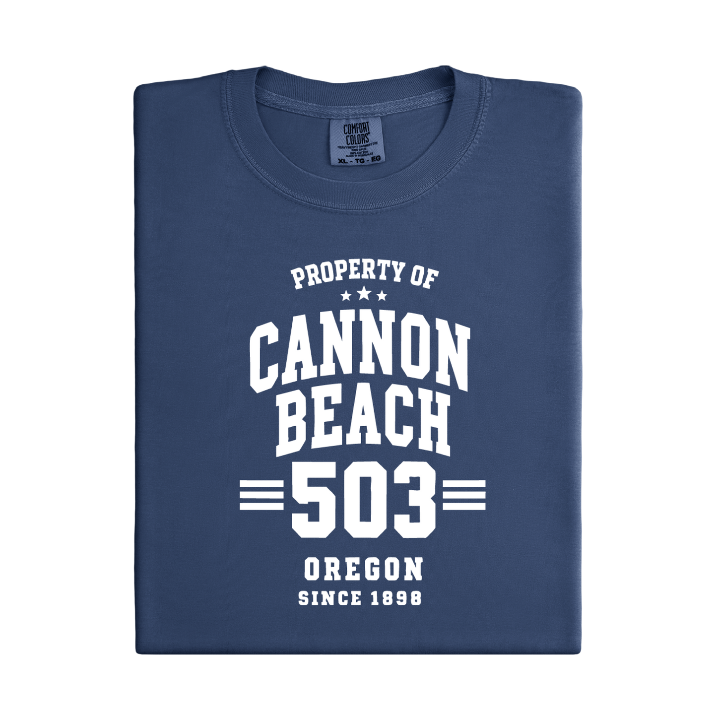 Folded navy blue t-shirt with white text 'Property of Cannon Beach 503 Oregon Since 1898' on a white background