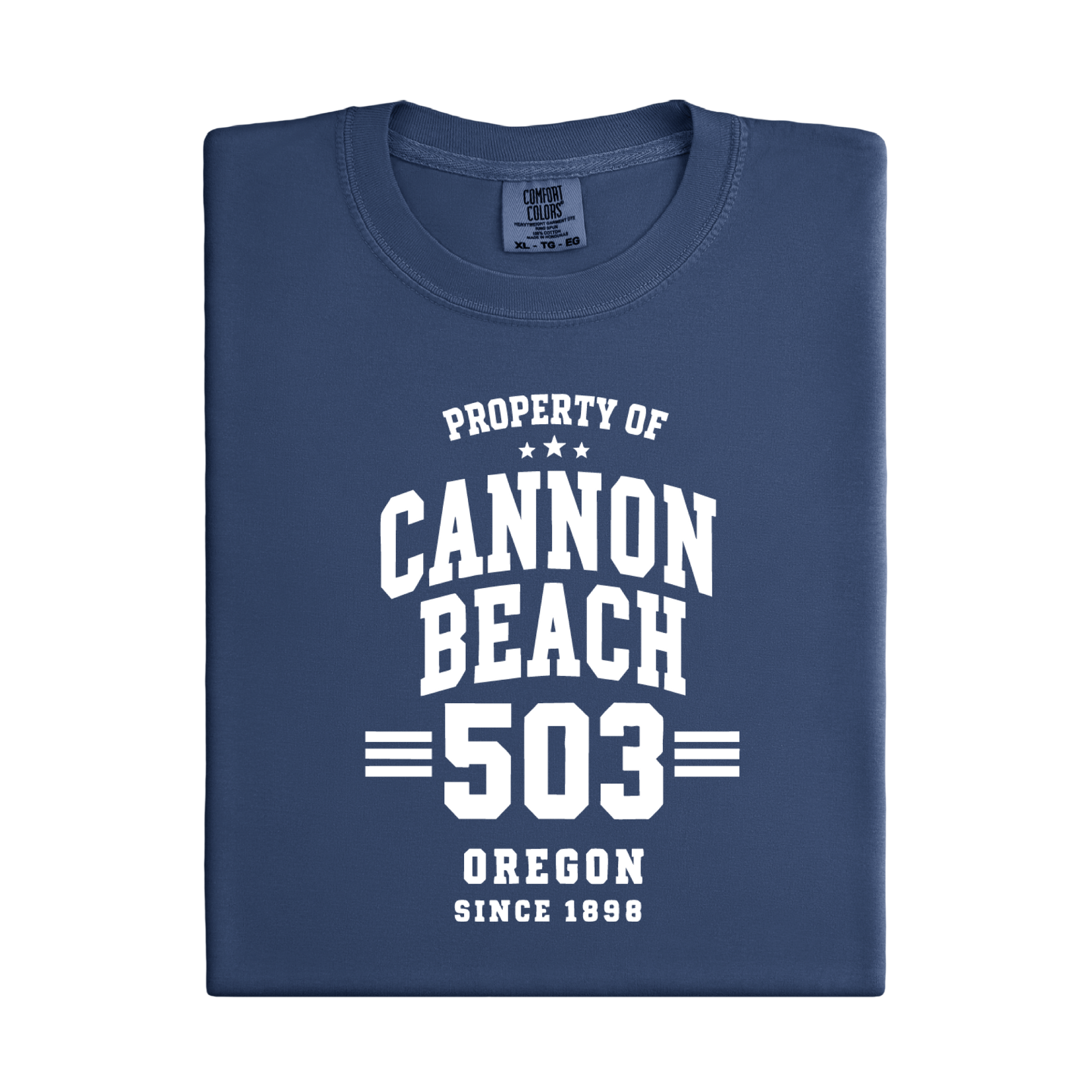 Folded navy blue t-shirt with white text 'Property of Cannon Beach 503 Oregon Since 1898' on a white background