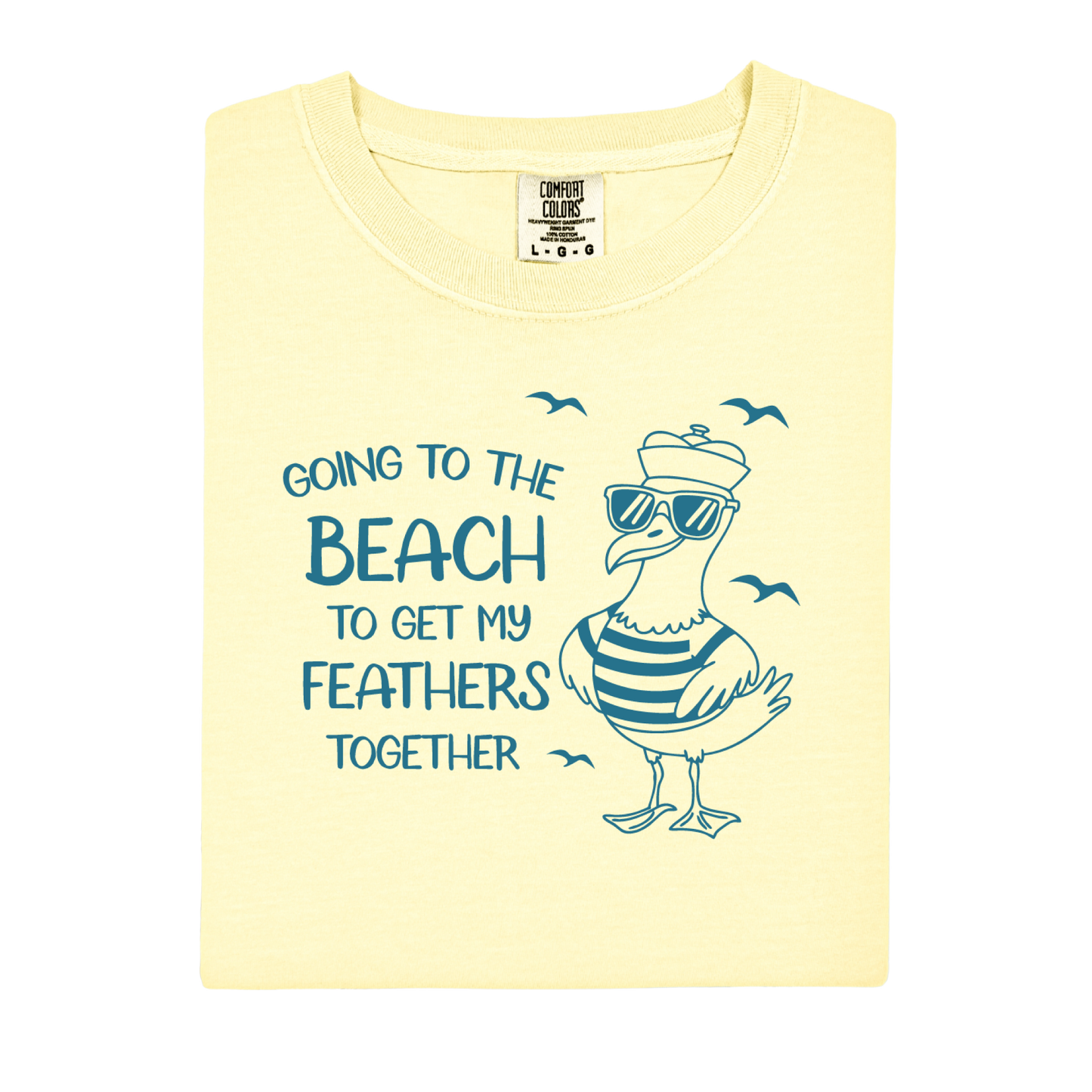 Comfort Colors t-shirt featuring a humorous blue seagull graphic wearing sunglasses and a striped shirt, beside the text “Going to the Beach to Get My Feathers Together.” Several flying birds surround the design, adding a fun coastal feel. This unisex garment-dyed tee offers a soft, vintage texture and relaxed fit, perfect for beach lovers, ocean fans, and anyone who enjoys playful summer graphic shirts.