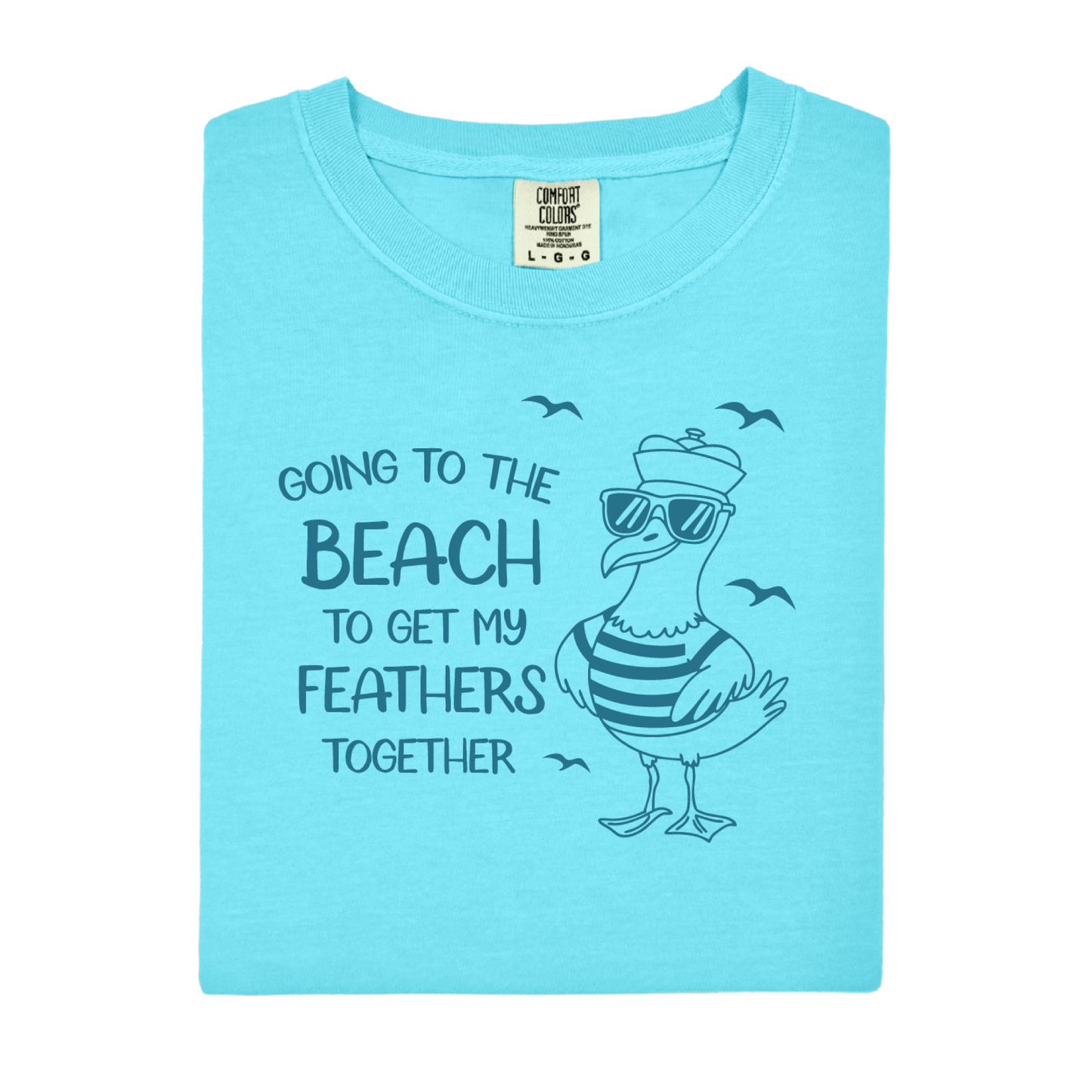 Comfort Colors t-shirt featuring a humorous blue seagull graphic wearing sunglasses and a striped shirt, beside the text “Going to the Beach to Get My Feathers Together.” Several flying birds surround the design, adding a fun coastal feel. This unisex garment-dyed tee offers a soft, vintage texture and relaxed fit, perfect for beach lovers, ocean fans, and anyone who enjoys playful summer graphic shirts.