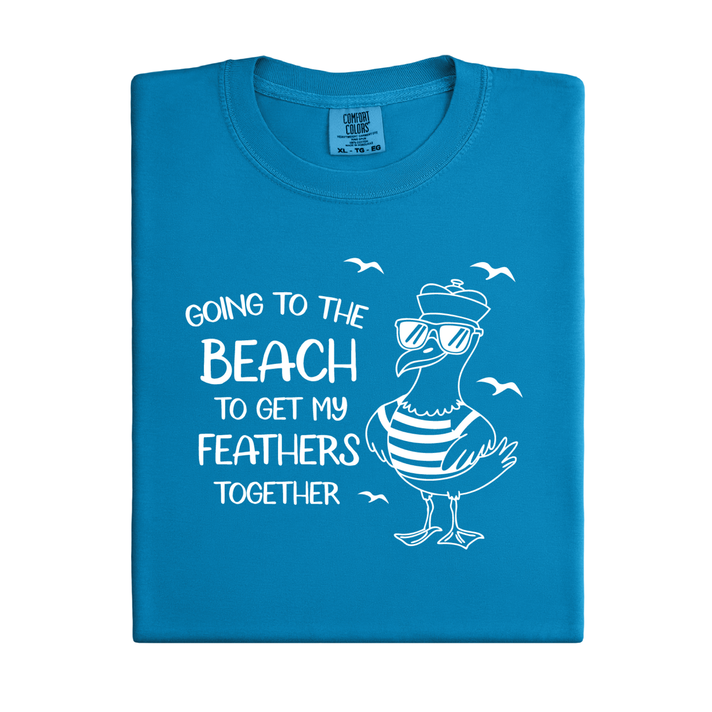 Comfort Colors t-shirt featuring a humorous blue seagull graphic wearing sunglasses and a striped shirt, beside the text “Going to the Beach to Get My Feathers Together.” Several flying birds surround the design, adding a fun coastal feel. This unisex garment-dyed tee offers a soft, vintage texture and relaxed fit, perfect for beach lovers, ocean fans, and anyone who enjoys playful summer graphic shirts.