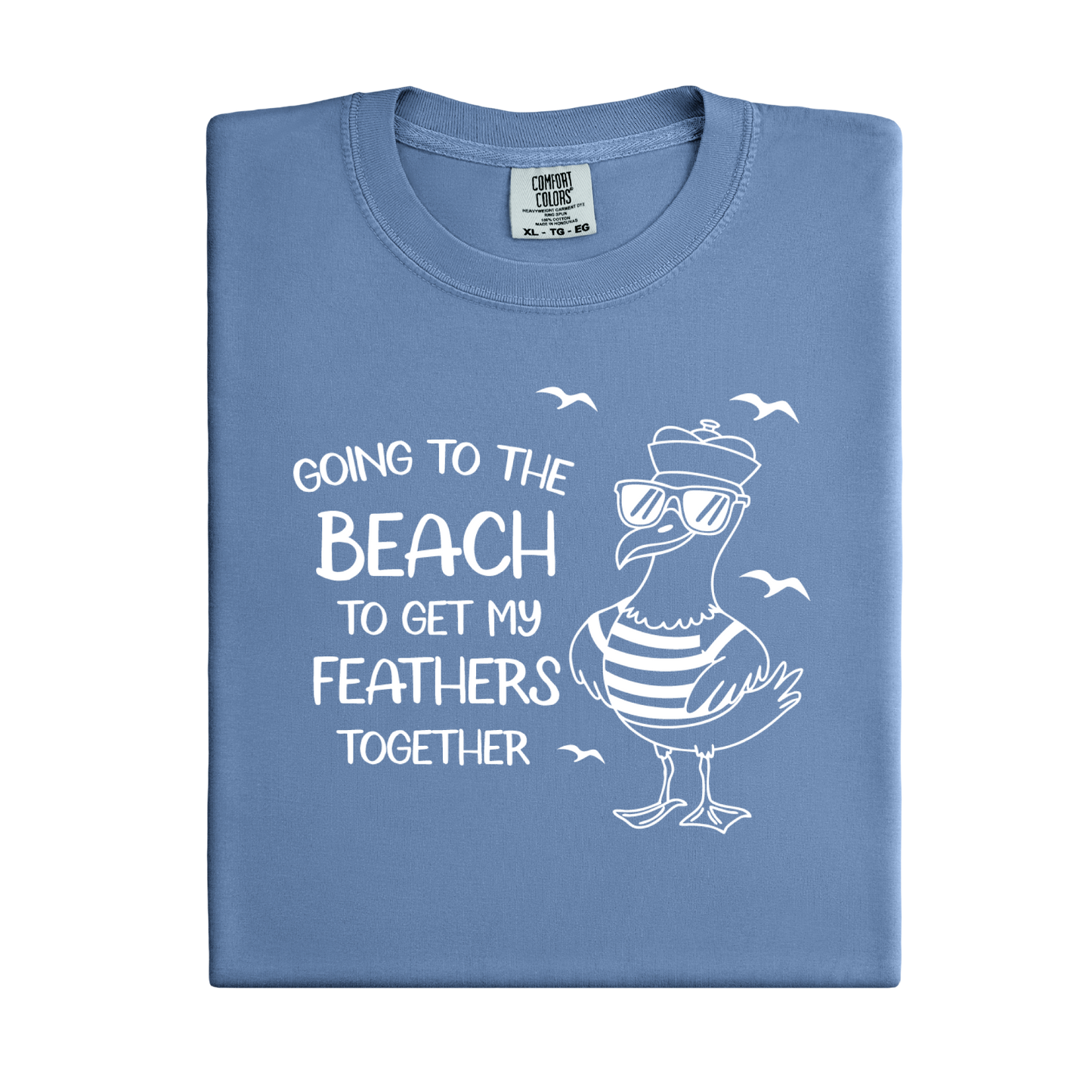 Comfort Colors t-shirt featuring a humorous blue seagull graphic wearing sunglasses and a striped shirt, beside the text “Going to the Beach to Get My Feathers Together.” Several flying birds surround the design, adding a fun coastal feel. This unisex garment-dyed tee offers a soft, vintage texture and relaxed fit, perfect for beach lovers, ocean fans, and anyone who enjoys playful summer graphic shirts.