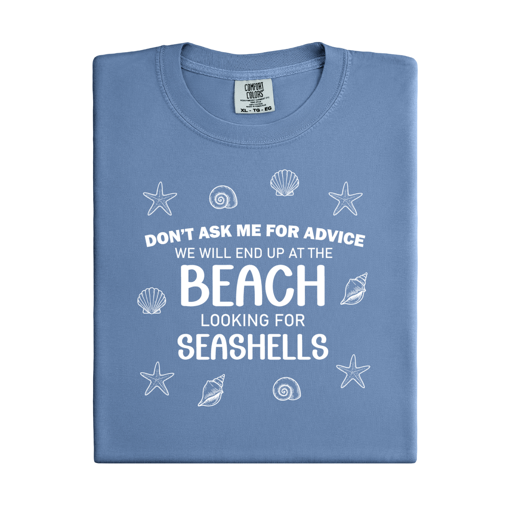 Folded blue t-shirt with beach-themed text and graphics on a white background