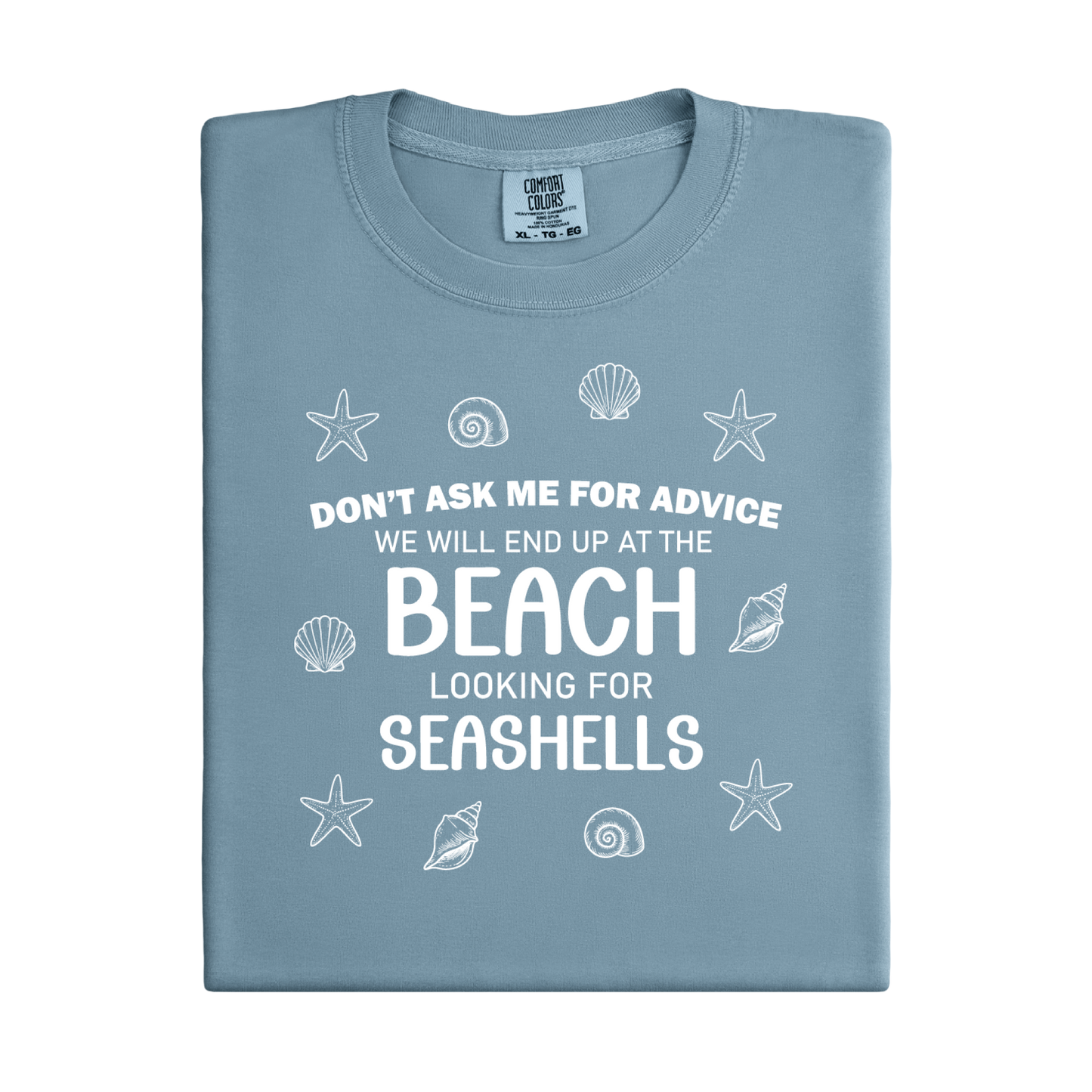 Folded blue t-shirt with beach-themed text and graphics on a white background