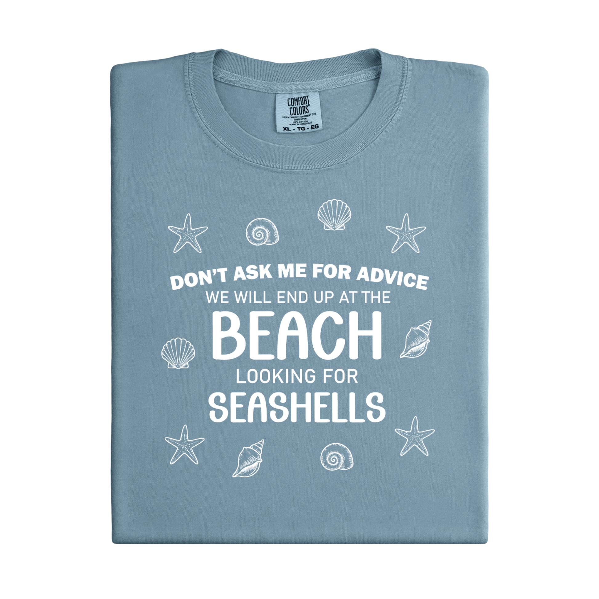 Folded blue t-shirt with beach-themed text and graphics on a white background