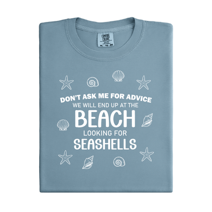 Folded blue t-shirt with beach-themed text and graphics on a white background