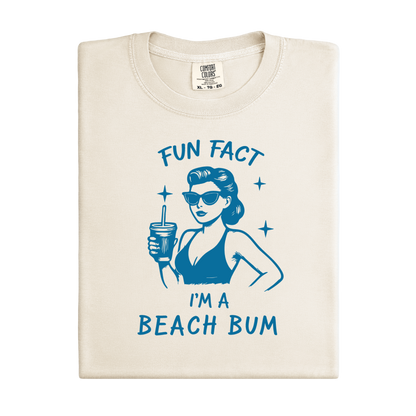 Folded t-shirt with a graphic of a woman at the beach and text 'Fun Fact I'm a Beach Bum' on a white background.