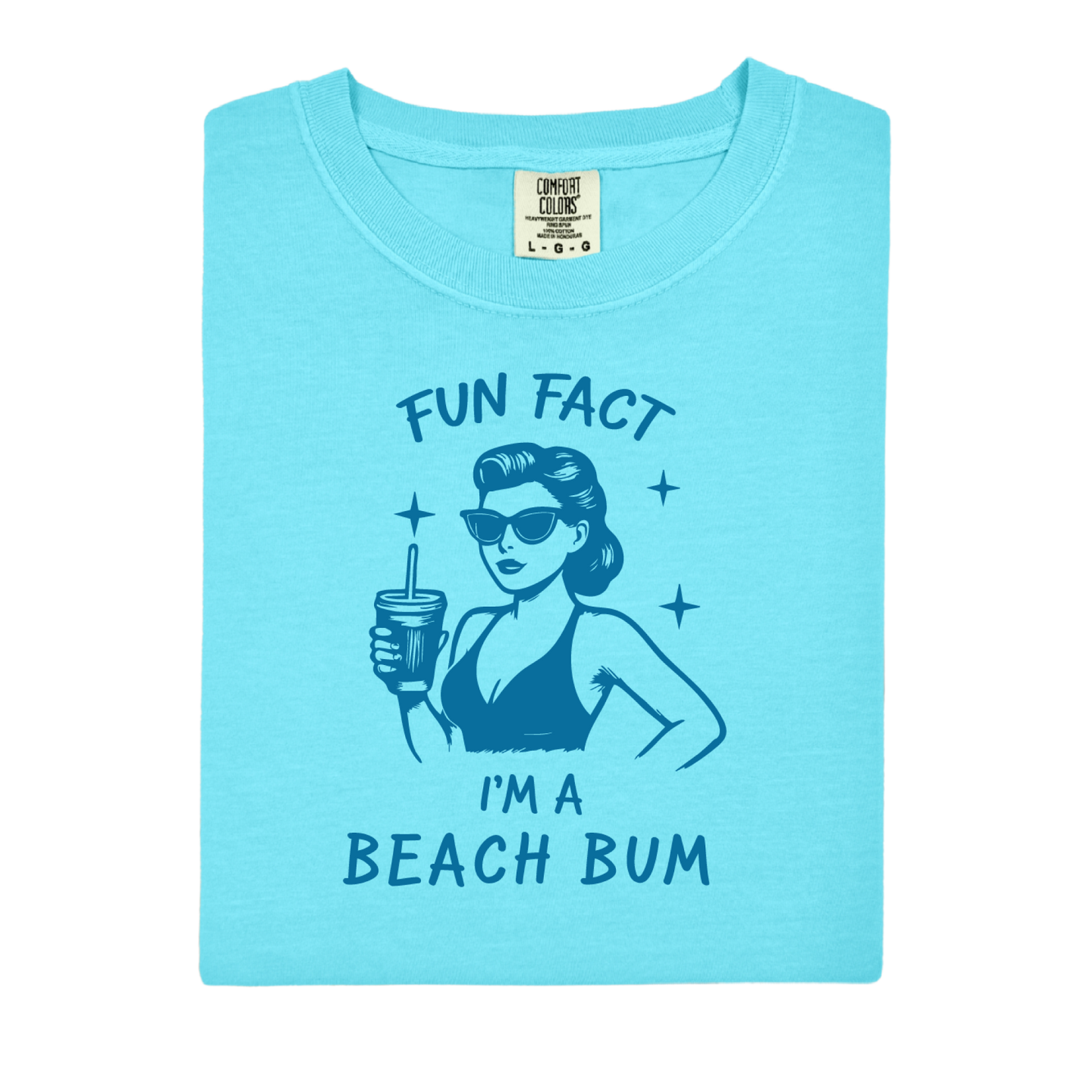 Light blue t-shirt with a graphic of a woman at the beach and text 'Fun Fact I'm a Beach Bum' on a white background.