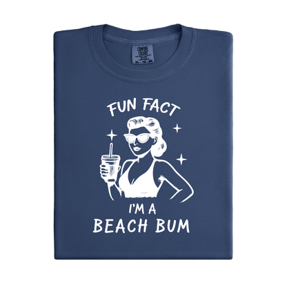 Folded navy blue t-shirt with a graphic of a woman at the beach and text 'Fun Fact I'm a Beach Bum' on a white background.