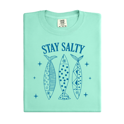 Light green t-shirt with 'Stay Salty' text and fish illustrations on a white background