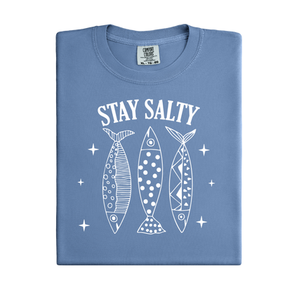 Folded blue t-shirt with 'Stay Salty' text and fish graphics on a white background