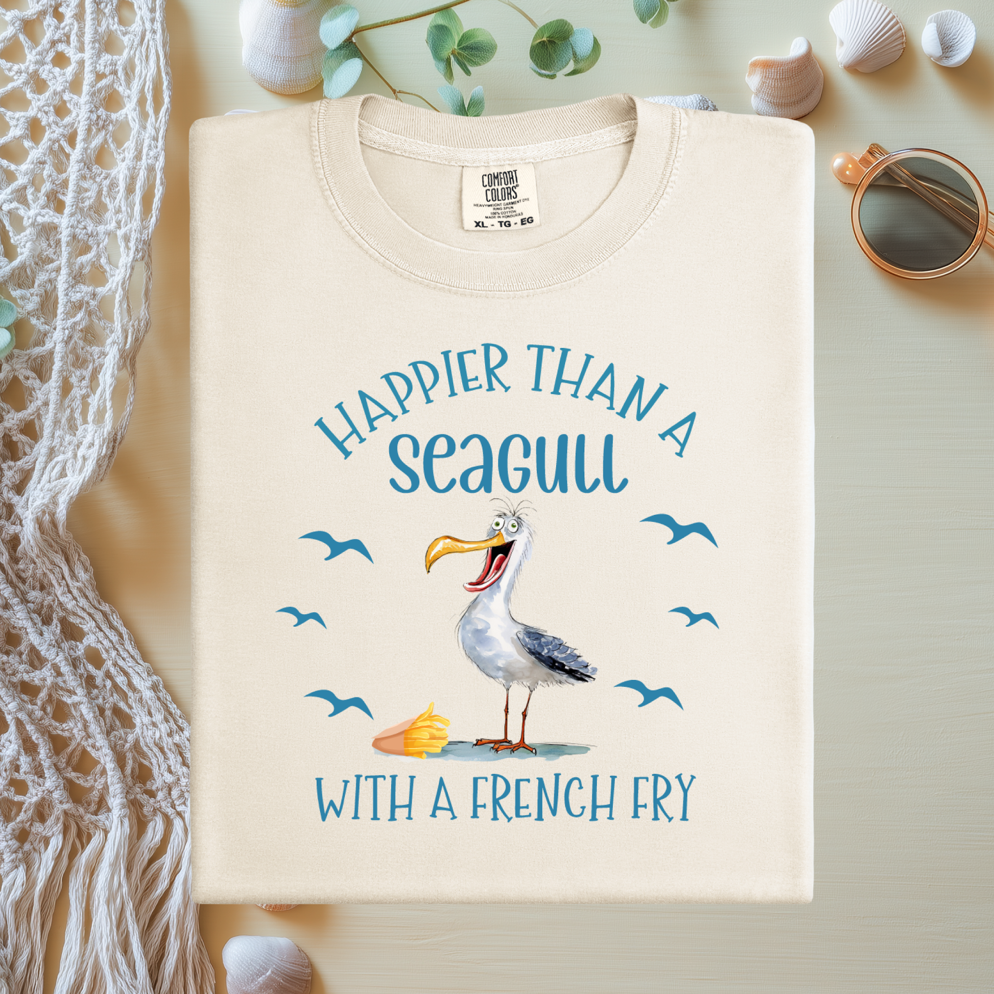 Beige t-shirt with a seagull graphic and text on a light background