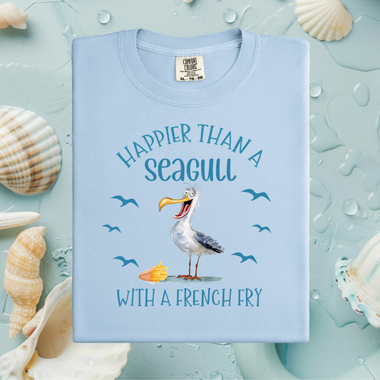 Light blue t-shirt with seagull graphic and text on a light blue background with shells.