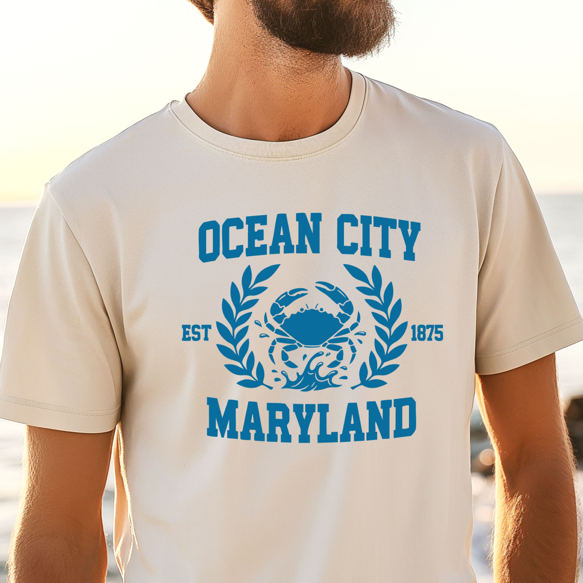 Person wearing a t-shirt with 'Ocean City, Maryland' design on a beach.