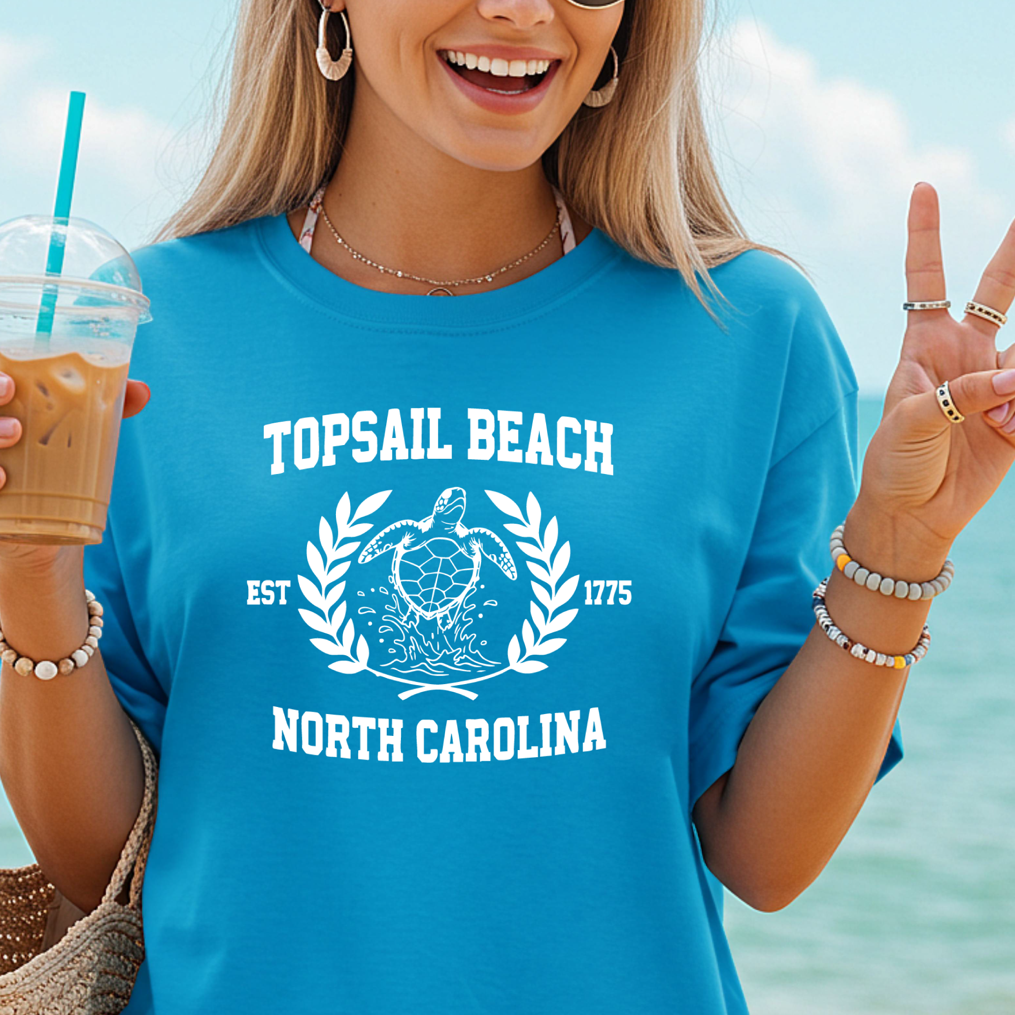 Woman wearing a blue sapphire 'Topsail Beach, North Carolina' t-shirt by the beach.