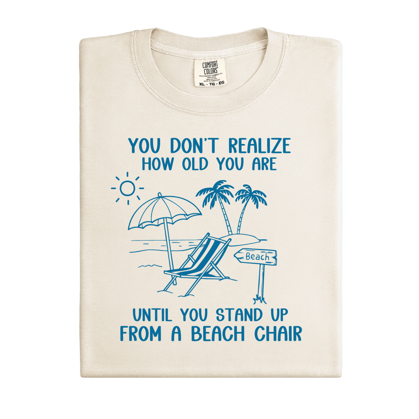 Beige t-shirt with blue beach-themed design and text on a white background