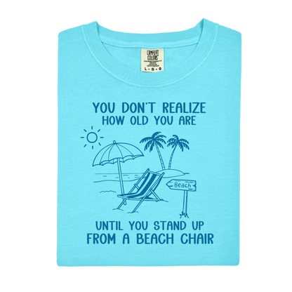 Light blue t-shirt with beach graphic and text on a white background