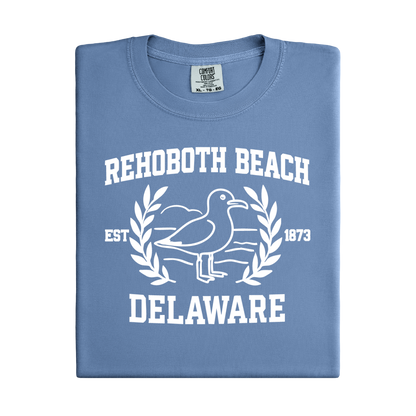 Folded blue t-shirt with white graphic and text 'Rehoboth Beach, Delaware' on a white background
