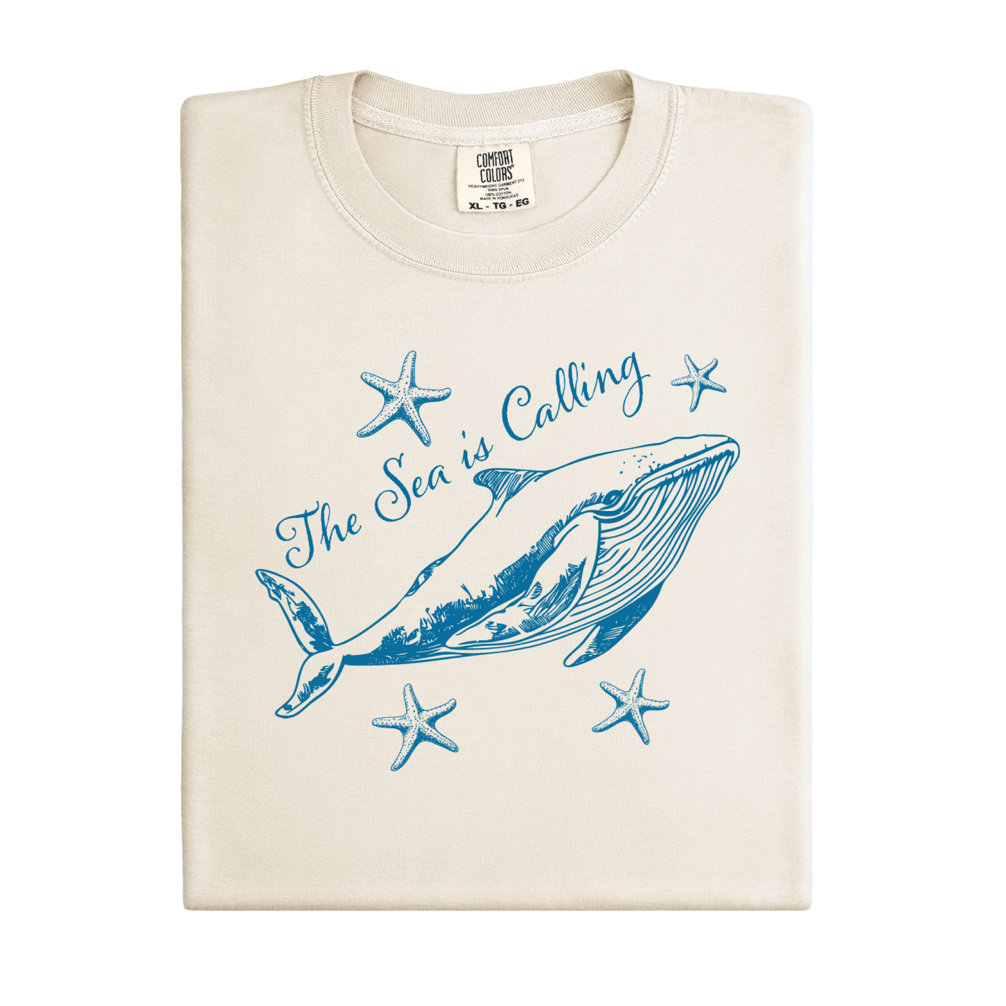 Comfort Colors t-shirt featuring a blue whale illustration surrounded by starfish and the handwritten-style text “The Sea is Calling.” The detailed marine artwork creates a calming coastal aesthetic. This unisex garment-dyed tee offers a soft vintage feel and relaxed fit, perfect for ocean lovers, beach trips, and anyone who enjoys sea-themed graphic shirts with a coastal vibe.
