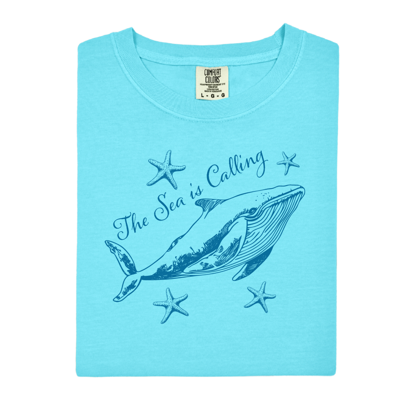 Comfort Colors t-shirt featuring a blue whale illustration surrounded by starfish and the handwritten-style text “The Sea is Calling.” The detailed marine artwork creates a calming coastal aesthetic. This unisex garment-dyed tee offers a soft vintage feel and relaxed fit, perfect for ocean lovers, beach trips, and anyone who enjoys sea-themed graphic shirts with a coastal vibe.