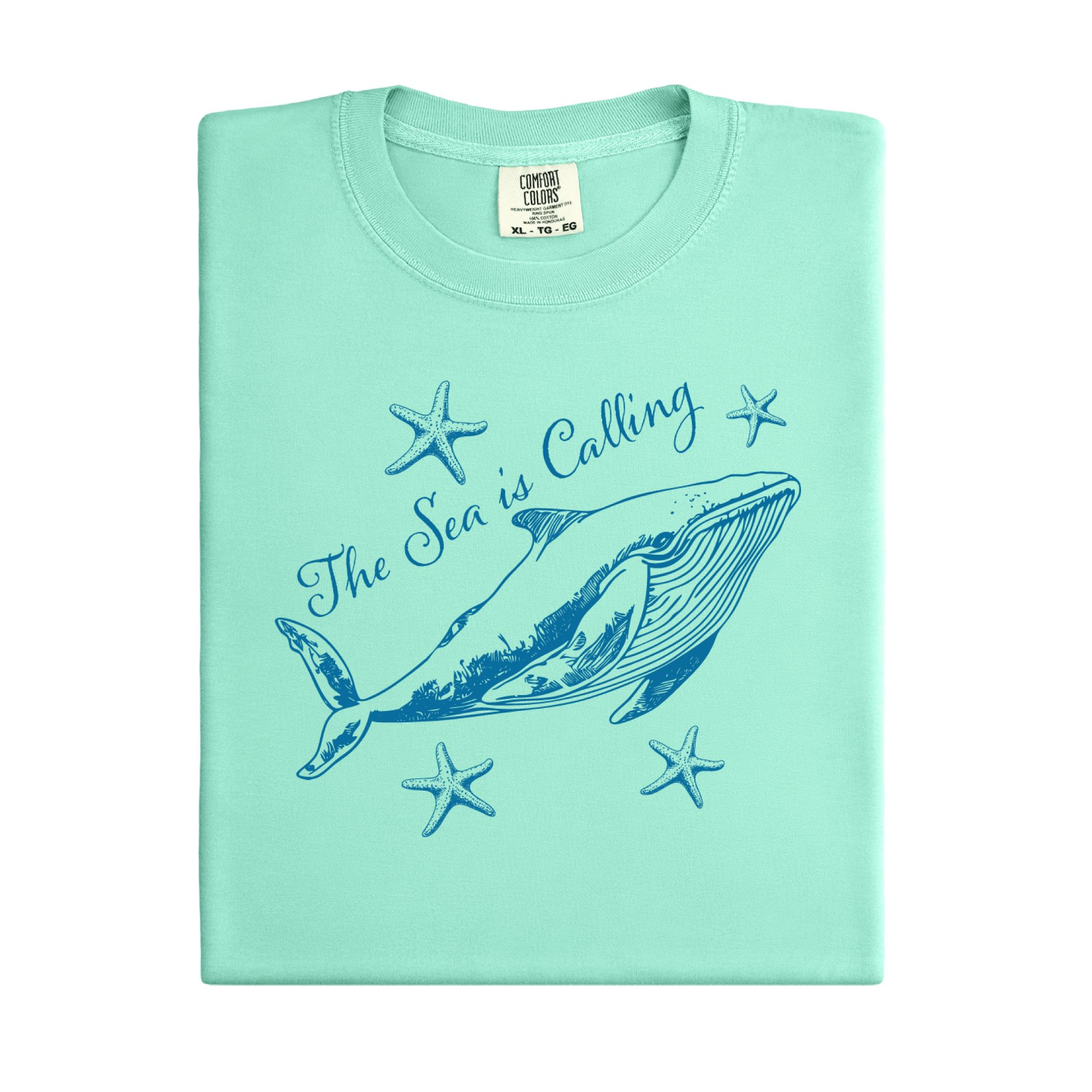 Comfort Colors t-shirt featuring a blue whale illustration surrounded by starfish and the handwritten-style text “The Sea is Calling.” The detailed marine artwork creates a calming coastal aesthetic. This unisex garment-dyed tee offers a soft vintage feel and relaxed fit, perfect for ocean lovers, beach trips, and anyone who enjoys sea-themed graphic shirts with a coastal vibe.