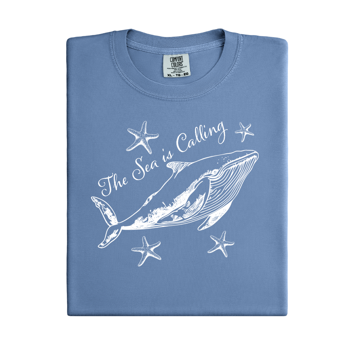Comfort Colors t-shirt featuring a blue whale illustration surrounded by starfish and the handwritten-style text “The Sea is Calling.” The detailed marine artwork creates a calming coastal aesthetic. This unisex garment-dyed tee offers a soft vintage feel and relaxed fit, perfect for ocean lovers, beach trips, and anyone who enjoys sea-themed graphic shirts with a coastal vibe.