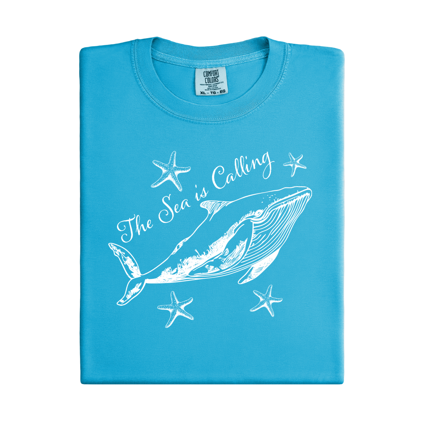 Comfort Colors t-shirt featuring a blue whale illustration surrounded by starfish and the handwritten-style text “The Sea is Calling.” The detailed marine artwork creates a calming coastal aesthetic. This unisex garment-dyed tee offers a soft vintage feel and relaxed fit, perfect for ocean lovers, beach trips, and anyone who enjoys sea-themed graphic shirts with a coastal vibe.
