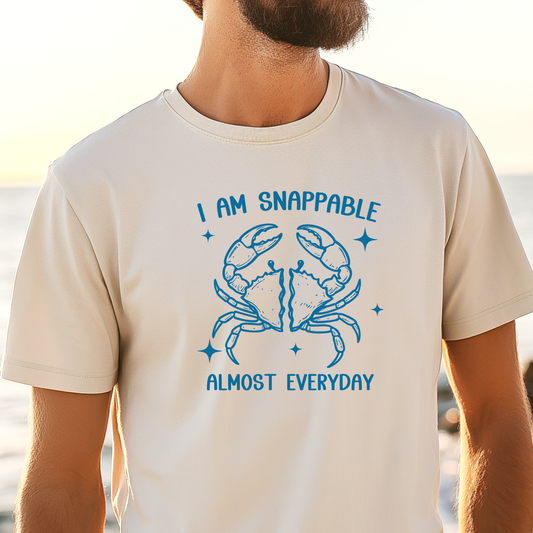 Person wearing a t-shirt with a blue crab graphic and text at a beach.