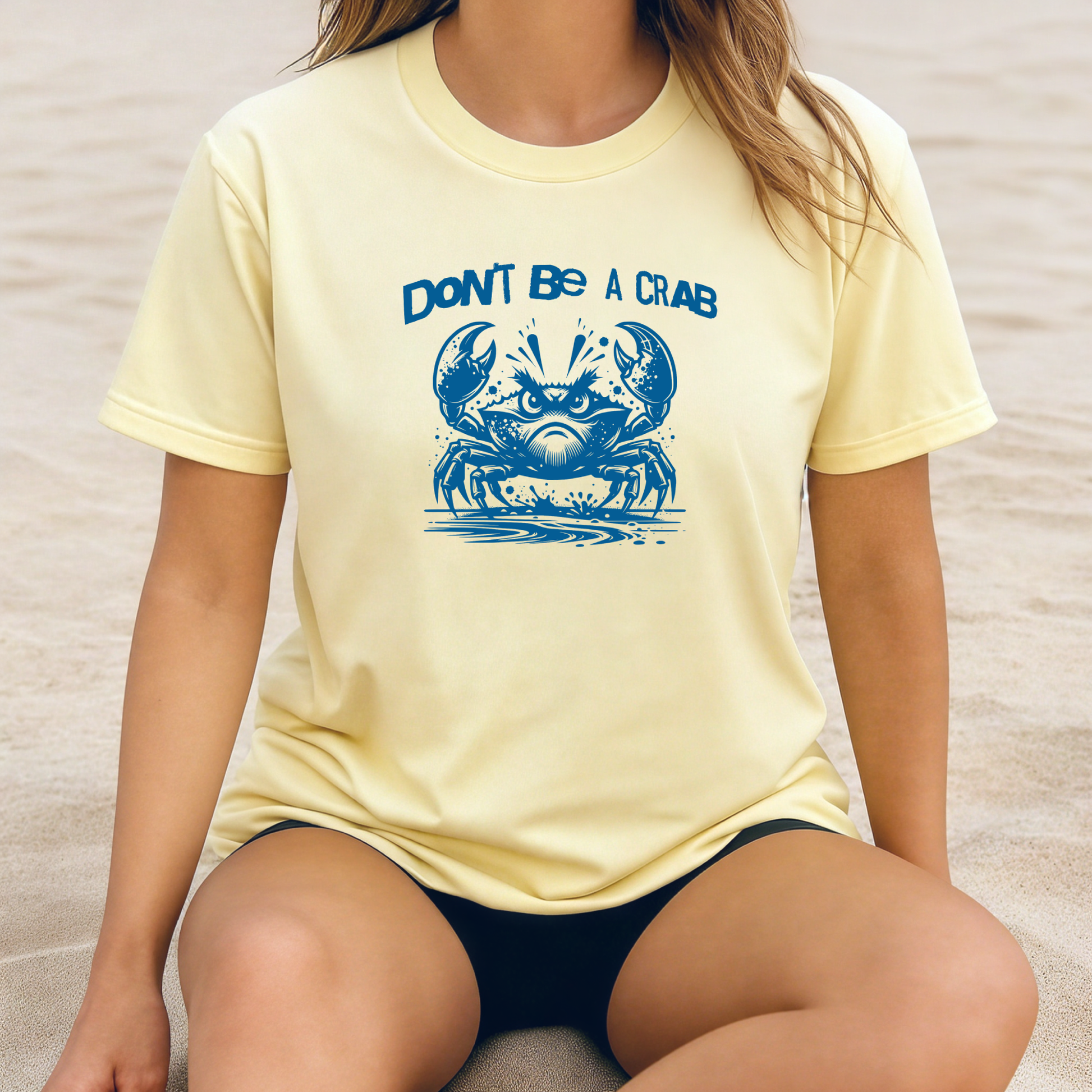Comfort Colors 1717 "Don't Be A Crab" t shirt with cute crab looking angry with  in a  one color graphic. Picture of a girl sitting on the beach wearing an oversized t shirt.
