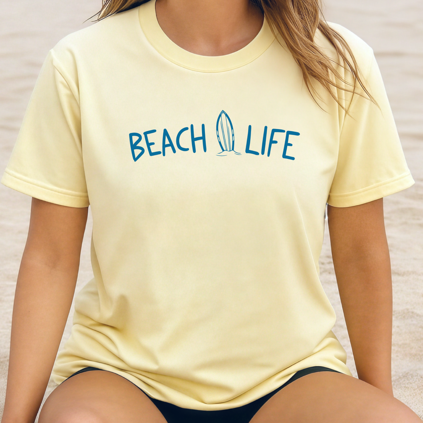 Person wearing a yellow 'Beach Life' t-shirt on a beach.