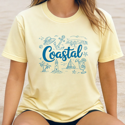Person wearing a yellow t-shirt with 'Coastal' design on a beach.