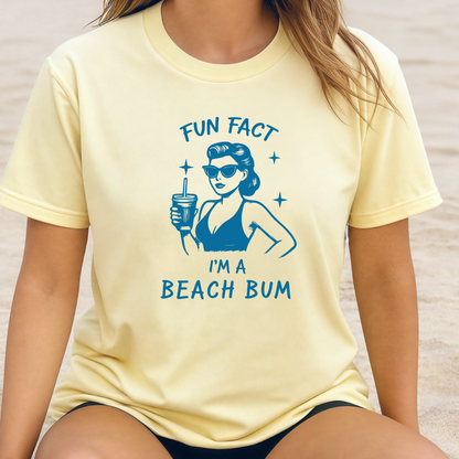 Person wearing a yellow t-shirt with a blue graphic and text 'Fun Fact I'm a Beach Bum' on a beach.