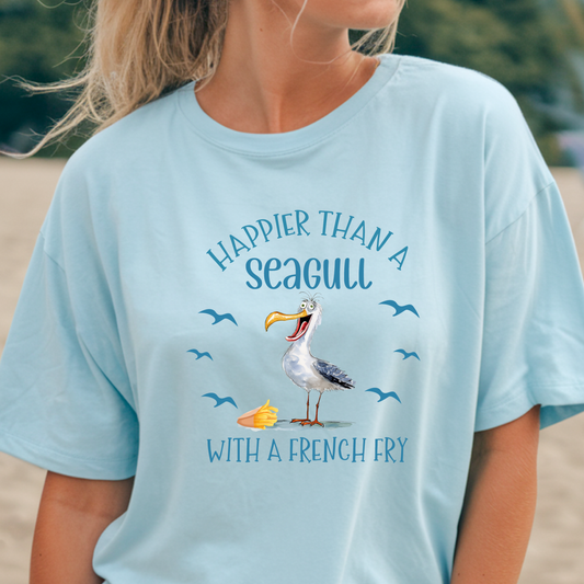 Light blue t-shirt with a seagull graphic and text worn by a person outdoors.