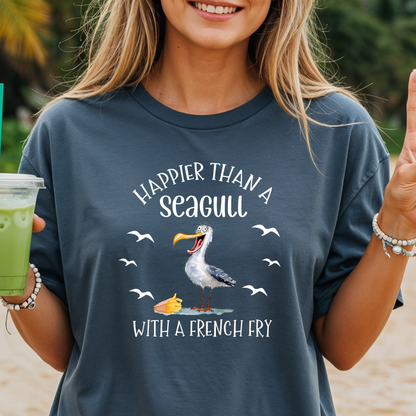 Person wearing a t-shirt with a seagull graphic and text on a beach.