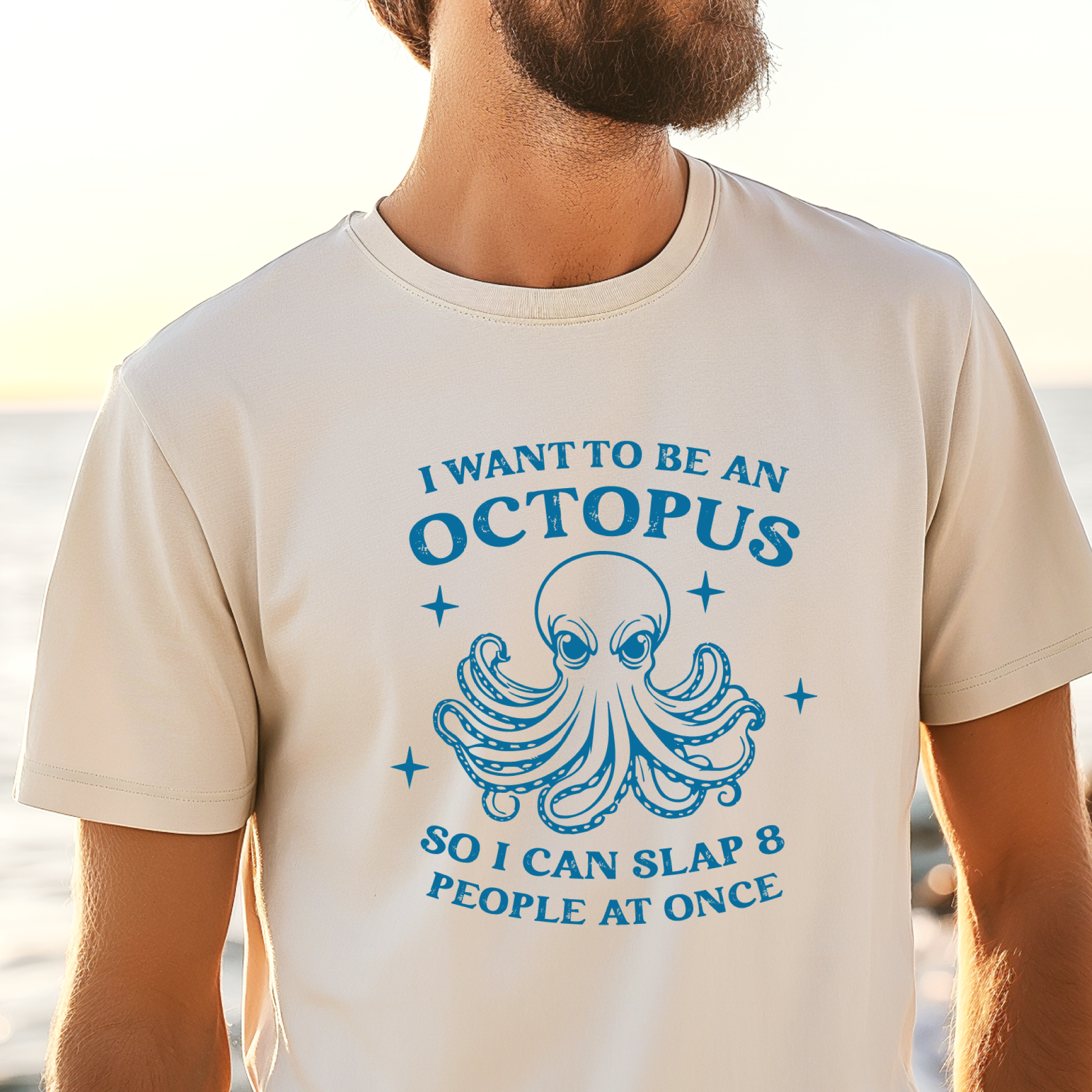 Person wearing a t-shirt with an octopus graphic and text at the beach
