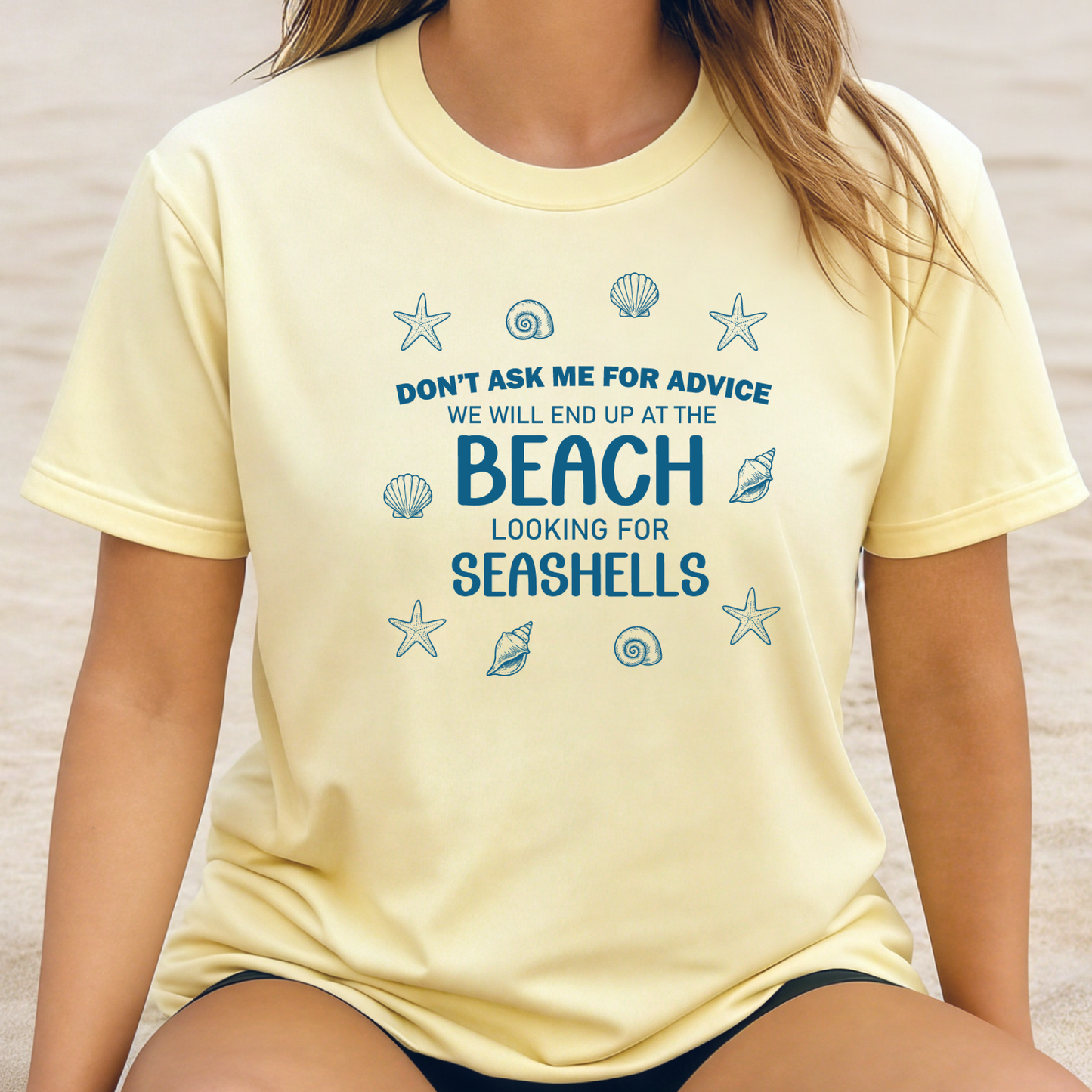Person wearing a yellow t-shirt with a beach-themed quote and graphics.